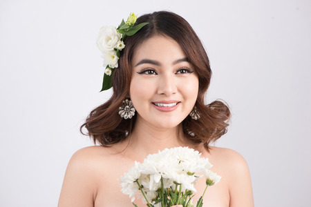 Beautiful asian woman bride on grey background. Closeup portraits with a professional makeupの写真素材