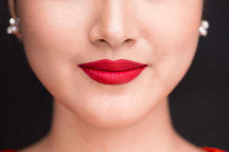 Beauty. Close up view of beautiful woman lips with red matt lipstickの写真素材