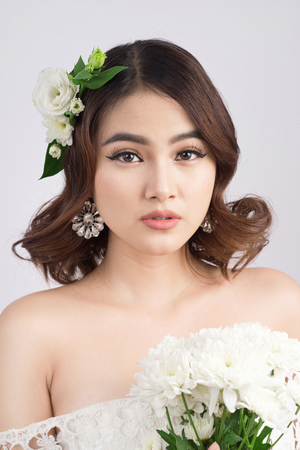 Beautiful asian woman bride on grey background. Closeup portraits with a professional makeupの写真素材