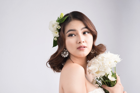 Beautiful asian woman bride on grey background. Closeup portraits with a professional makeupの写真素材