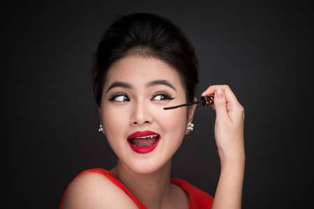Make-up and cosmetics concept. Asian woman doing her makeup eyelashes black mascara.の写真素材