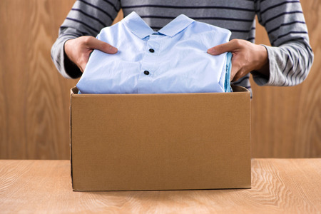 Donation box for poor with clothing in male handsの写真素材