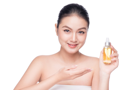 Health, spa and beauty concept. Asian woman with perfect skin holding oil bottleの写真素材