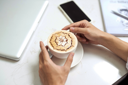 Asian businessman using mobile phone  during coffee break on table in coffee shopの写真素材