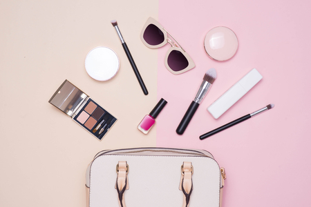 Flat lay of female fashion accessories and white handbag on pastel color background with copyspaceの写真素材