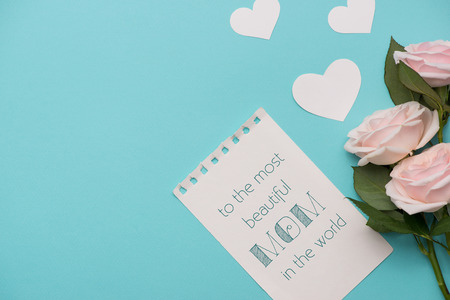Mother's Day concept. Pink roses with gift box and lipstick. Open notebook for copy space.の写真素材