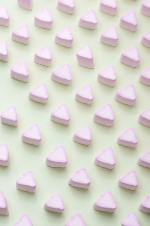 Valentines Day candy hearts marshmallows over green backgroundの写真素材