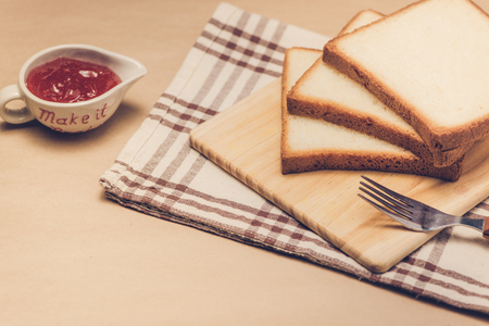 Toast with strawberry jam on a plate on table.の写真素材