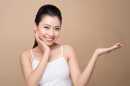 Proposing a product. Beautiful spa woman showing empty copy space on the open hand palmの写真素材