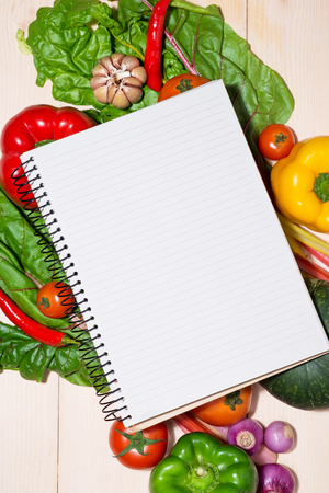 Notebook for culinary recipes with fresh organic vegetablesの写真素材