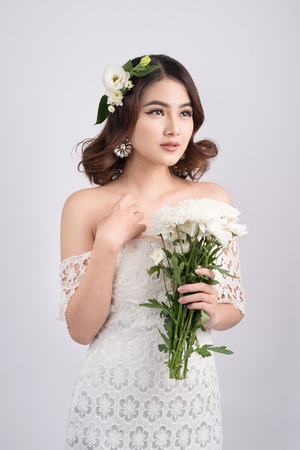 Beautiful asian woman bride on grey background. Closeup portraits with a professional makeupの写真素材