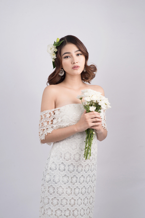 Beautiful asian woman bride on grey background. Closeup portraits with a professional makeupの写真素材