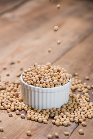 Soya beans or soybeans on wooden table.の写真素材