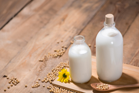 Soy milk or soya milk and soy beans in spoon on wooden table.の写真素材