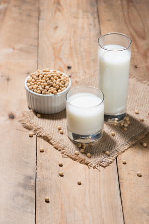 Soy milk or soya milk and soy beans in spoon on wooden table.の写真素材