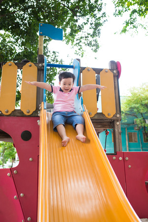 Happy little boy having fun at playground in summer.の写真素材