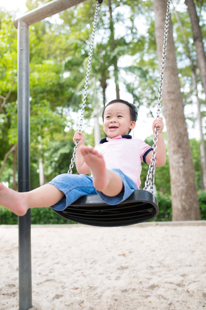 Happy little boy having fun at playground in summer.の写真素材