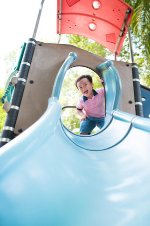 Happy little boy having fun at playground in summer.の写真素材