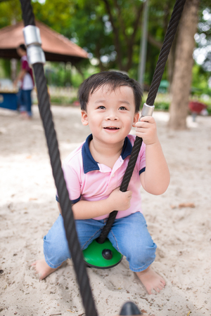 Happy little boy having fun at playground in summer.の写真素材