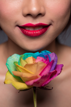 Beautiful asian woman face with perfect makeup with flowers of a roseの写真素材