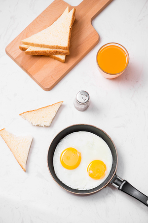 Traditional breakfast with fried eggs on a plateの写真素材