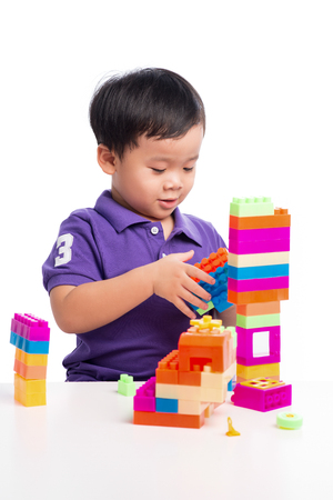Kid boy playing with blocks from toy constructor isolatedの写真素材