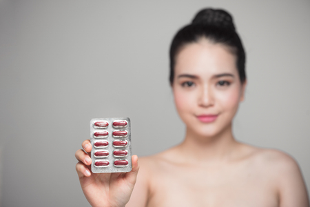 Healthy happy asian woman with pills in hand.の写真素材