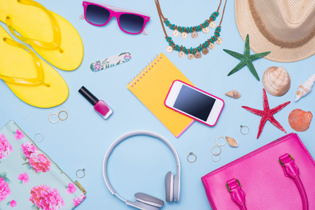 Summer concept. Pink handbag with accessories on light blue backgroundの写真素材