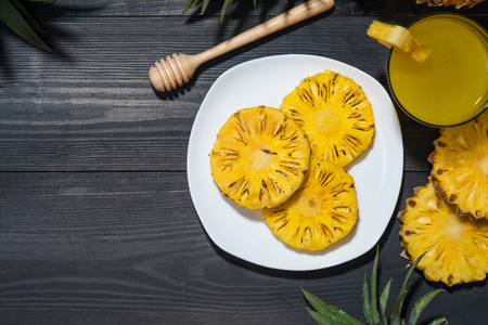 Grilled pineapple on a black wooden tableの写真素材