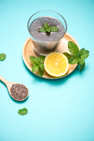 Selective focus of chia seeds drink with water in transparent glass with lemon balm.の写真素材