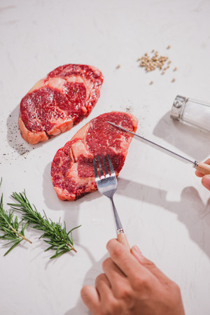 Raw beef on a cutting board  with spices and ingredients for cooking.の写真素材