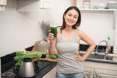Young asian woman enjoy healthy vegetarian smoothie for weight loss and detoxの写真素材