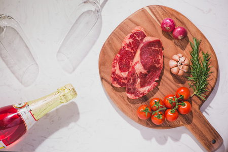 Raw beef on a cutting board  with spices and ingredients for cooking.の写真素材
