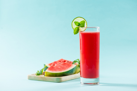 Glass of healthy watermelon juice in summertime on blue background.の写真素材