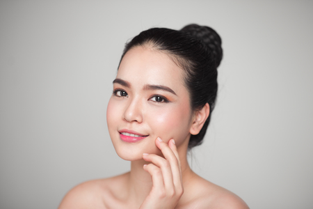 Happy smiling beautiful asian woman touching her face.の写真素材