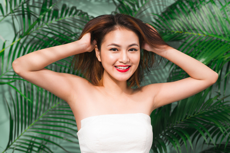 Tropical summer holiday fashion beauty concept. Summer style portrait of young attractive asian woman.の写真素材