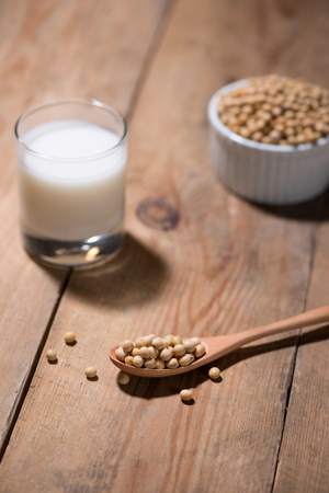 Soy milk or soya milk and soy beans in spoon on wooden table.の写真素材