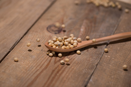 Soya beans in spoon on wooden table.の写真素材