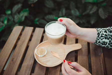 Closeup woman hand holding cup of coffee in cafeの写真素材