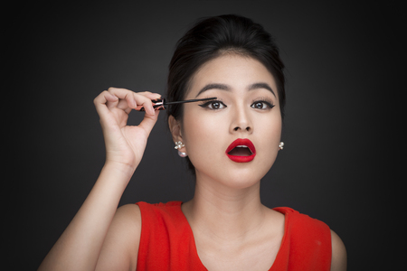 Make-up and cosmetics concept. Asian woman doing her makeup eyelashes black mascara.の写真素材