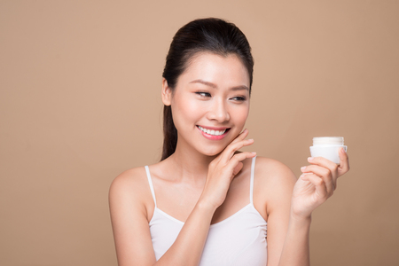 Skincare. Beautiful asian woman show moisturizer or lotion product.の写真素材