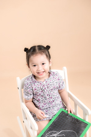 Asian child holding empty board, studio shotの写真素材