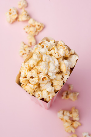 Popcorn in red and white cardboard box on the pink background.の写真素材