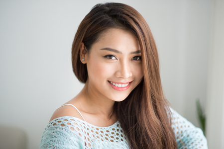 Beautiful asian woman relaxing in the morning sitting indoors.の写真素材