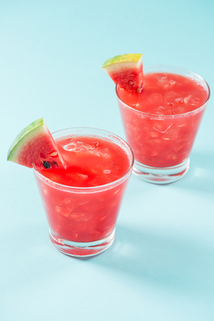 Glass of healthy watermelon juice in summertime on blue background.の写真素材