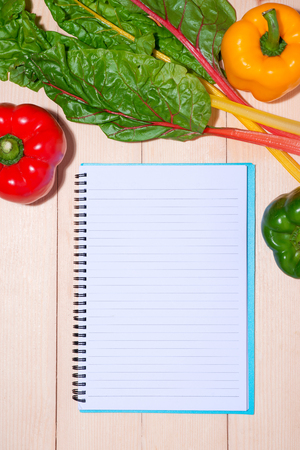 Notebook for culinary recipes with fresh organic vegetablesの写真素材