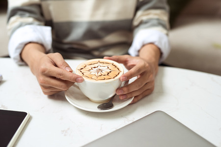 Asian businessman using mobile phone  during coffee break on table in coffee shopの写真素材