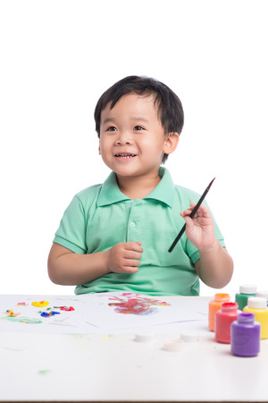 Portrait of cheerful asian boy painting using watercolorsの写真素材