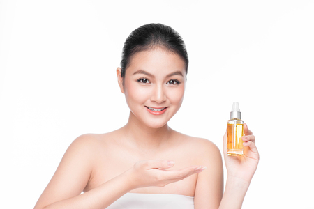 Health, spa and beauty concept. Asian woman with perfect skin holding oil bottleの写真素材