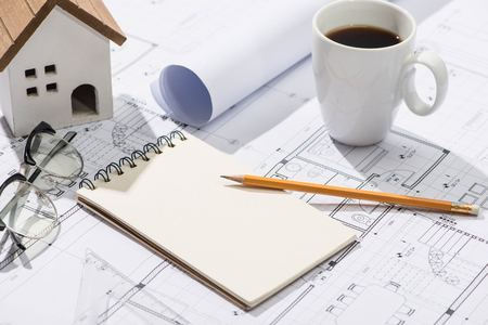 Construction projects. Planning. Open blueprints with a pencil and notebook.の写真素材